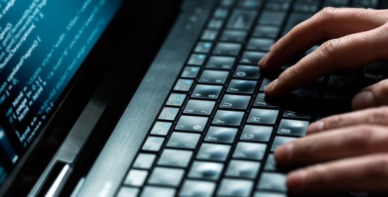 Hands typing on a computer