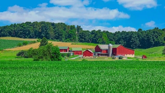 Big red barn and grass field and hill in Indiana
