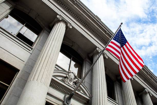 US government building with the American flag hanging in front of it